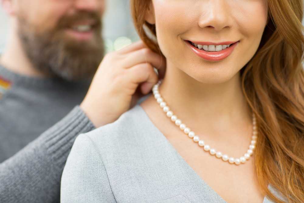 Man-Putting-Pearl-Necklace-on-Woman